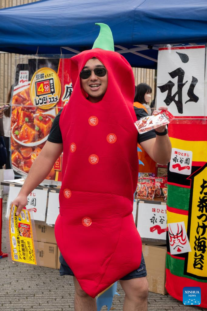 A staff member in chili pepper costume is pictured during a Sichuan food festival held at Nakano Central Park, Tokyo, Japan, on May 14, 2023. The Sichuan food festival was held here from May 13 to May 14. (Xinhua/Zhang Xiaoyu)