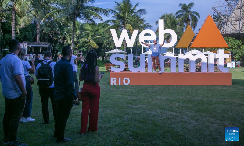 A man takes photos with the logo of the Web Summit Rio in Rio de Janeiro, Brazil, May 1, 2023. The Web Summit Rio kicked off here on Monday. (Photo by Claudia Martini/Xinhua)