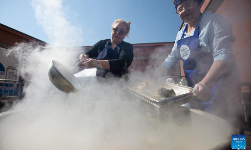 People cook smelt fish at the smelt fest in St. Petersburg, Russia, May 13, 2023. (Photo by Irina Motina/Xinhua)