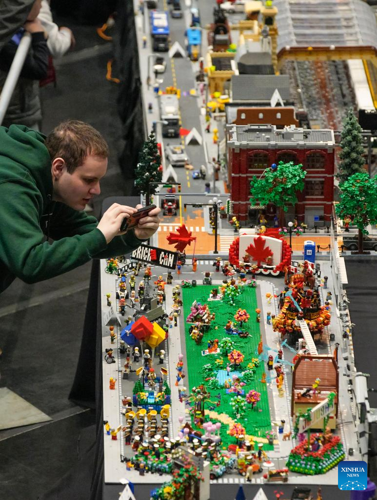 A visitor takes photos of a LEGO work at the BrickCan LEGO exhibition at the River Rock Theatre in Richmond, British Columbia, Canada, on April 22, 2023. Over 300 LEGO builders from around the world showcased their creations at BrickCan 2023, which was held here in Richmond between April 22 and 23. (Photo by Liang Sen/Xinhua)