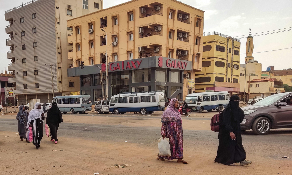 Women walk along a street in the south of Khartoum on April 24, 2023. Photo: VCG
