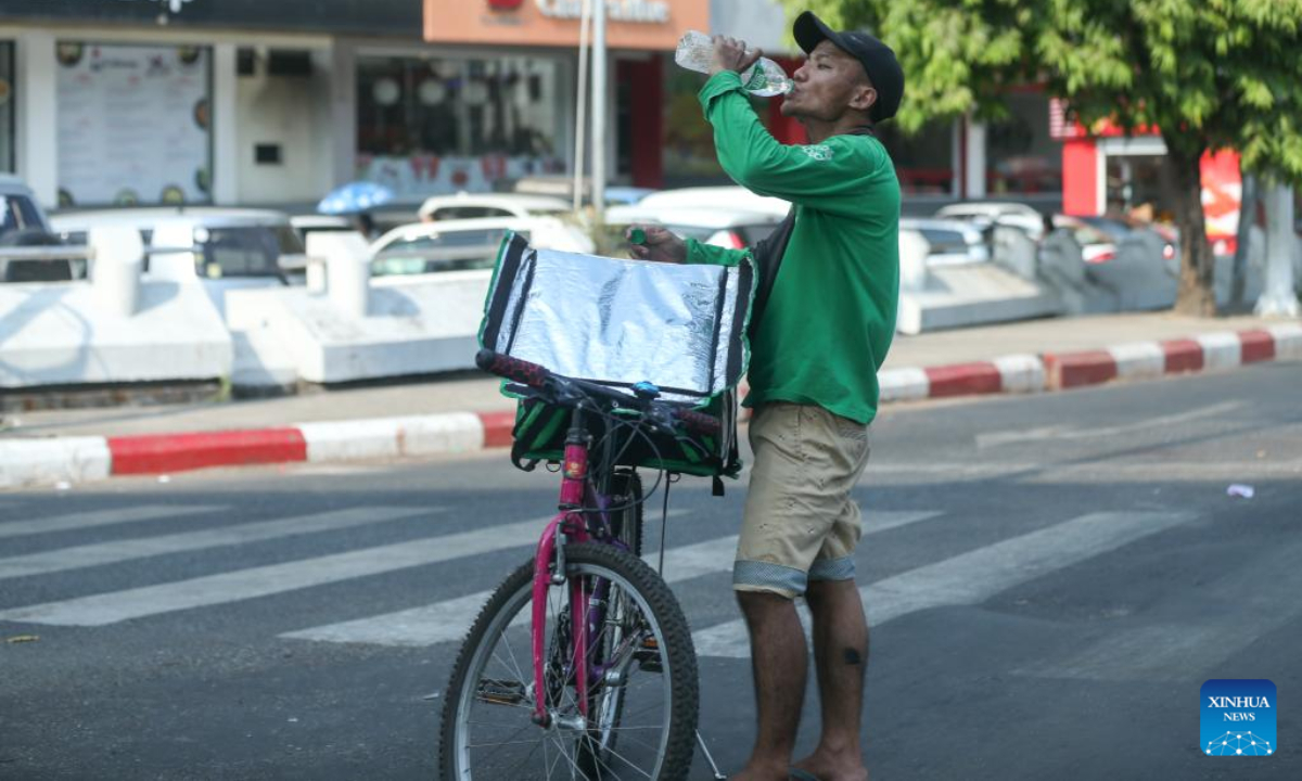 A man drinks water on a hot day in Yangon, Myanmar, April 27, 2023. Photo:Xinhua