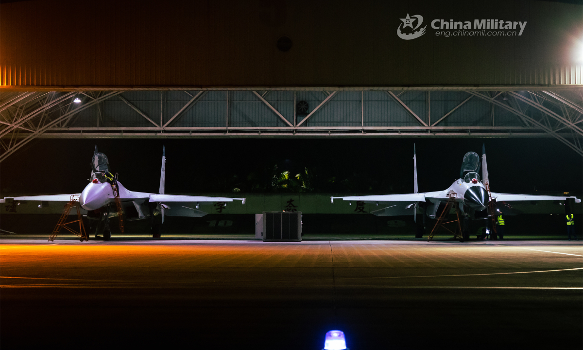 Maintenance men assigned to a naval aviation brigade under the PLA Southern Theater Command perform thorough inspections on fighter jets prior to a recent night flight training exercise focusing on courses including area air-defense, covering assault and force-on-force training. Photo: China Military
