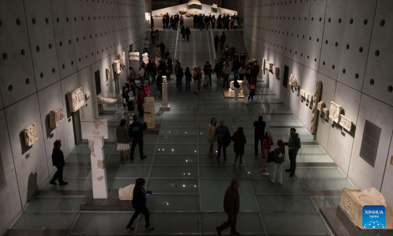 This photo taken on May 13, 2023 shows people watching the ancient masterpieces of museum collection at the Acropolis Museum in Athens, Greece. (Photo by Lefteris Partsalis/Xinhua)