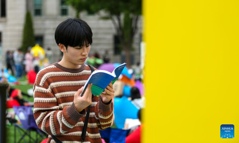 A man reads a book at Seoul Plaza in Seoul, South Korea, April 23, 2023. Reading activities were held at Seoul Plaza and Gwanghwamun Square in downtown Seoul on the occasion of World Book Day, which falls on April 23 every year. (Xinhua/Wang Yiliang)