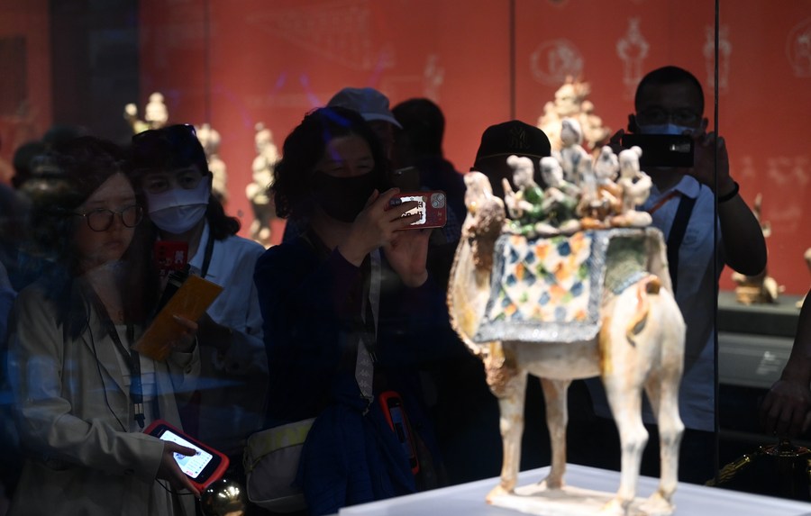 Tourists look at a Tang Dynasty (618-907) tri-colored figurine depicting camel-riding musicians at Shaanxi History Museum in Xi'an, northwest China's Shaanxi Province, May 11, 2023. (Xinhua/Li Yibo)