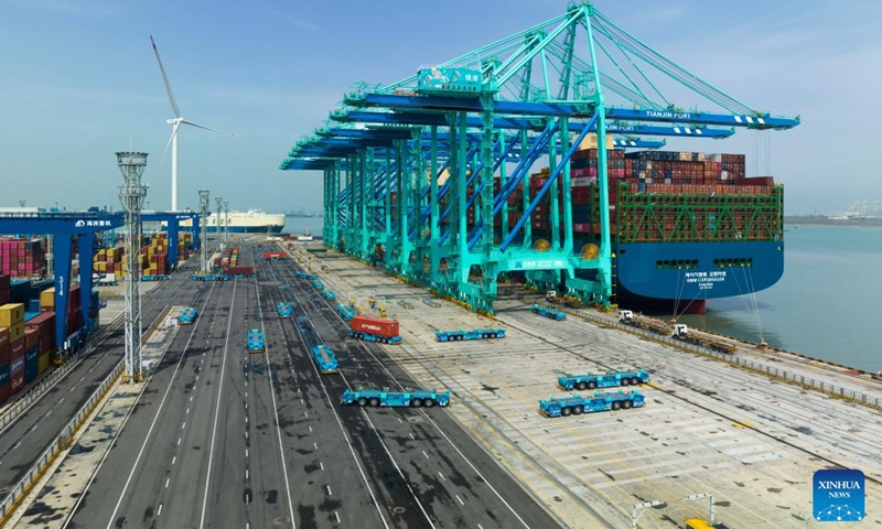 This aerial photo taken on April 6, 2023 shows a container ship at the smart zero-carbon terminal of Tianjin Port in north China's Tianjin. North China's Tianjin Port handled approximately 5.047 million twenty-foot equivalent units (TEUs) of containers in the first three months of 2023, up 9.09 percent year on year.(Photo: Xinhua)