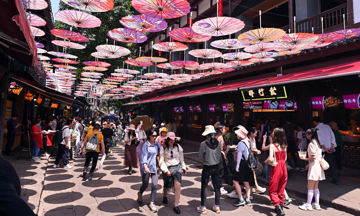 Туристы посещают популярное туристическое место в муниципалитете Чунцин на юго-западе Китая, 16 апреля 2023 года. По мере приближения пятидневных первомайских праздников многие места по всему Китаю вступили в период разогрева из-за резкого увеличения числа туристов. 