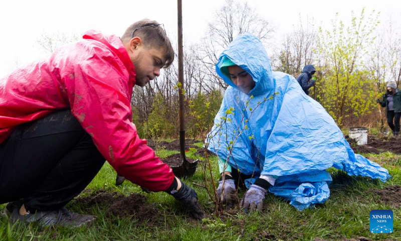 People participate in a tree planting event in a park in Toronto, Canada, on April 22, 2023. About 200 people took part in a tree planting event here on Saturday to celebrate Earth Day. (Photo by Zou Zheng/Xinhua)