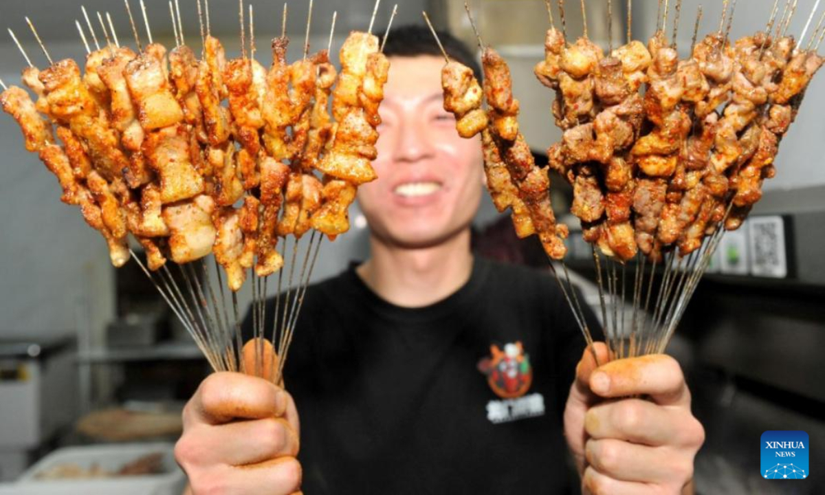 A chef holds grilled meat at a barbecue eatery in Zibo, east China's Shandong Province, April 11, 2023. Photo:Xinhua