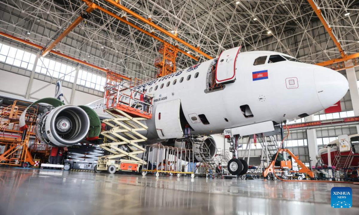 Workers of Grand China Aviation Maintenance Co., Ltd. (GCAM) maintain an airplane in Haikou, capital of south China's Hainan Province, May 5, 2023. An Airbus A320 airplane of Cambodia Airways was parked at a hangar of Hainan Free Trade Port's aircraft maintenance base to receive examination and maintenance services provided by GCAM on Friday. Photo:Xinhua
