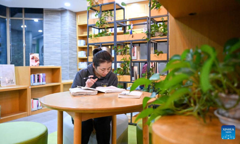 A woman reads books at a bookstore in Hexi District, north China's Tianjin, April 19, 2023. Hexi District in north China's Tianjin Municipality has offered convenient reading service to its readers by developing a reading service system. With the system, libraries in the district can share their resources and readers can borrow and return books by one stop. (Xinhua/Sun Fanyue)