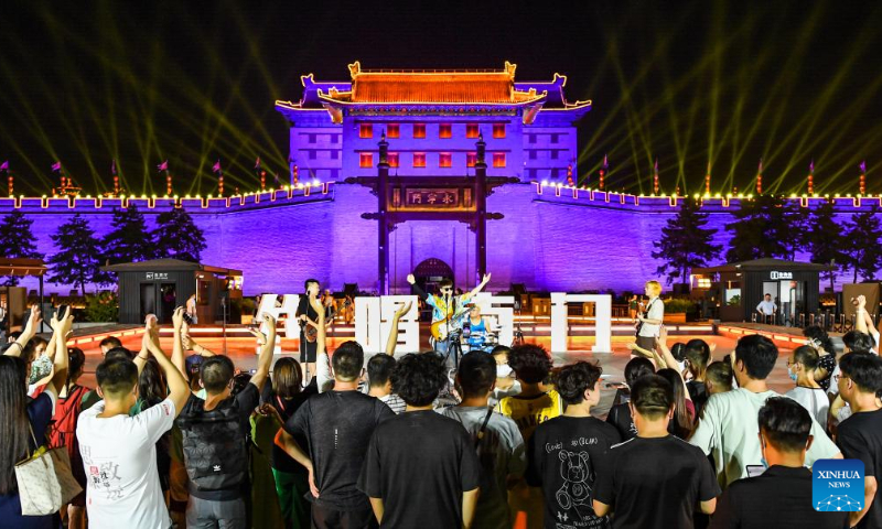 Tourists enjoy a show staged by a band in front of the Yongning Gate of the ancient city wall of Xi'an, northwest China's Shaanxi Province, Aug. 1, 2022. (Photo by Zou Jingyi/Xinhua)