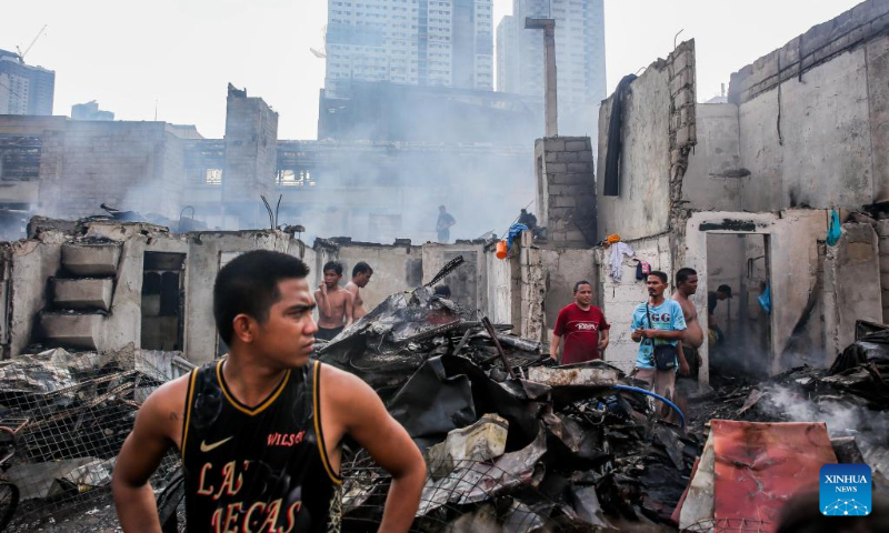 Residents search for their belongings from their charred houses after an early morning fire at a slum area in Manila, the Philippines, May 14, 2023. (Xinhua/Rouelle Umali)