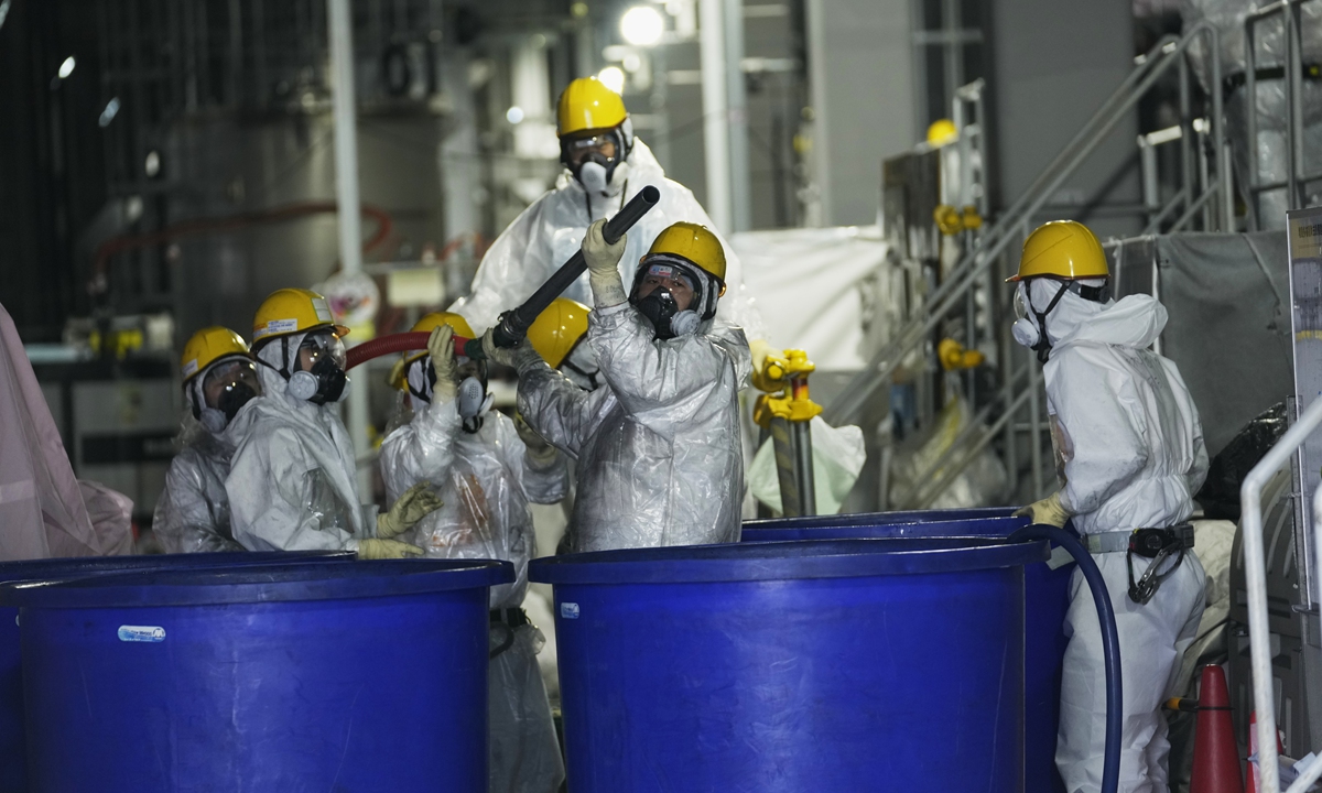 Workers in hazmat suits work inside a facility with equipment to remove radioactive materials from nuclear-contaminated wastewater at the Fukushima Daiichi nuclear power plant, on March 3, 2022.