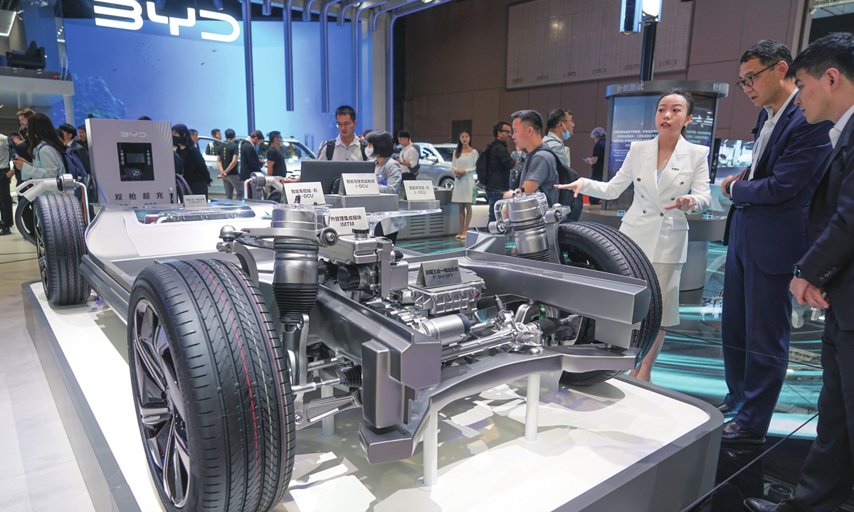 A BYD staff member introduces the front drive 3-in-1 electric power transmission assembly of  a car to the visitors. Photo: Lu Ting/GT