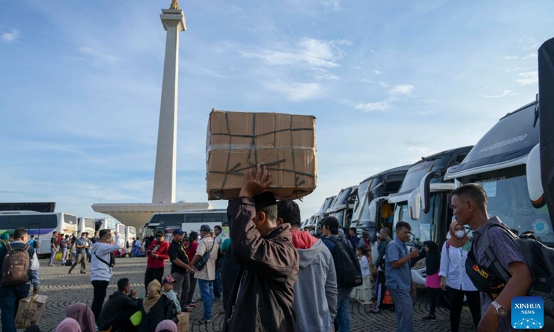 People carry belongings to board free-of-charge buses to their hometowns in Jakarta, Indonesia, April 17, 2023. Indonesia is facing the homecoming season when people from urban cities return to their respective hometowns to celebrate Eid with their families(Photo: Xinhua)
