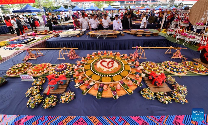 Judges evaluate candidate creations for a contest of colorful meals made with glutinous rice at a cultural square in Dahua Yao Autonomous County, south China's Guangxi Zhuang Autonomous Region, April 15, 2023. A gourmet competition was held here on Saturday to mark the traditional Sanyuesan festival, which falls on the third day of the third month on the lunar calendar. Hundreds of dishes made with indigenous produces participated in the competition. (Xinhua/Huang Xiaobang)