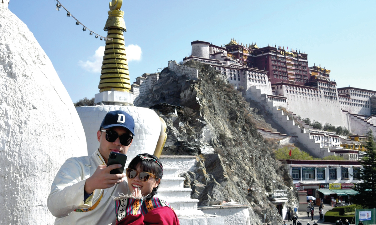 Tourists dressed in ethnic clothing take pictures in front of the Potala Palace in Lhasa, Southwest China's Xizang Autonomous Region on April 17, 2023. The tourism market in Lhasa continues to pick up, as data from the regional tourism development department shows that in the first quarter of 2023, Lhasa received 1.808 million tourists from both home and abroad, a year-on-year increase of 20.33 percent. Photo: VCG