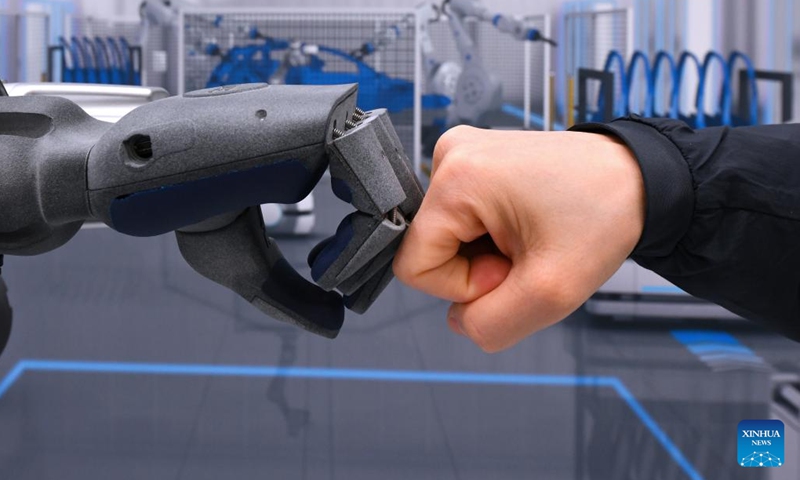 A visitor interacts with an intelligent robot at Hannover Messe 2023 in Hannover, Germany, April 19, 2023. The trade fair, one of the world's largest and lasting from April 17 to April 21, showcases more than 4,000 companies, which present solutions for the production and energy supply of the future.(Photo: Xinhua)