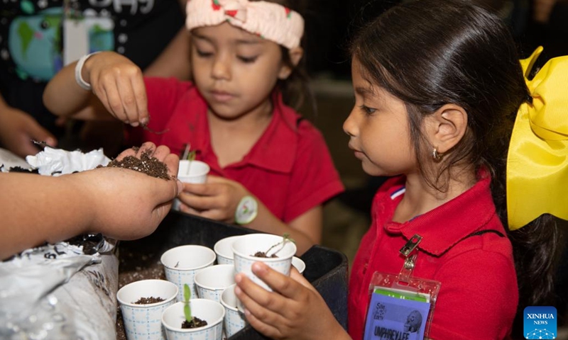 Children learn how to plant flowers at the Earthx2023 in Dallas, Texas, the United States, on April 21, 2023. The Earthx2023, an Earth Day event, kicked off here on Friday, highlighting a wide range of environmental and sustainability-related topics.(Photo: Xinhua)