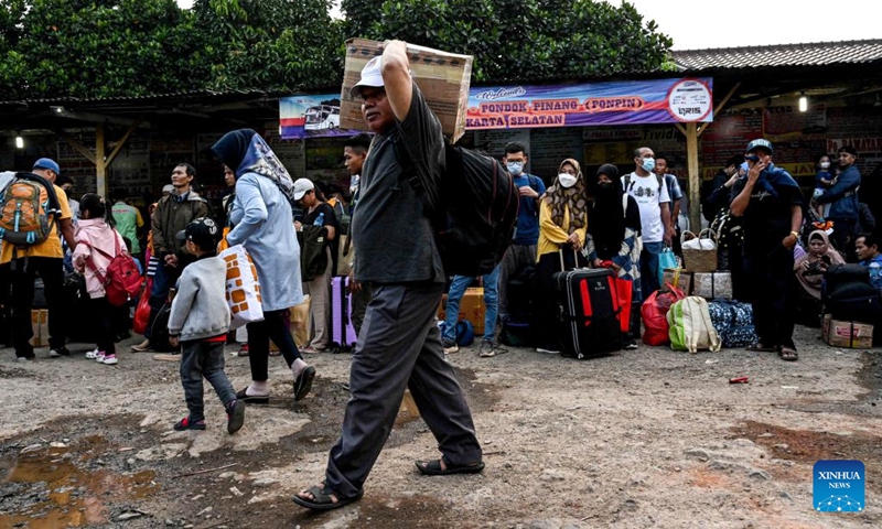 A passenger carries his belongings before boarding a bus ahead of the upcoming Eid al-Fitr at Pondok Pinang bus terminal in Jakarta, Indonesia, April 18, 2023. Authorities in Indonesia are calling on citizens to travel to their hometowns for the Eid al-Fitr celebration earlier than usual to avoid heavy traffic congestion during the upcoming holiday.(Photo: Xinhua)