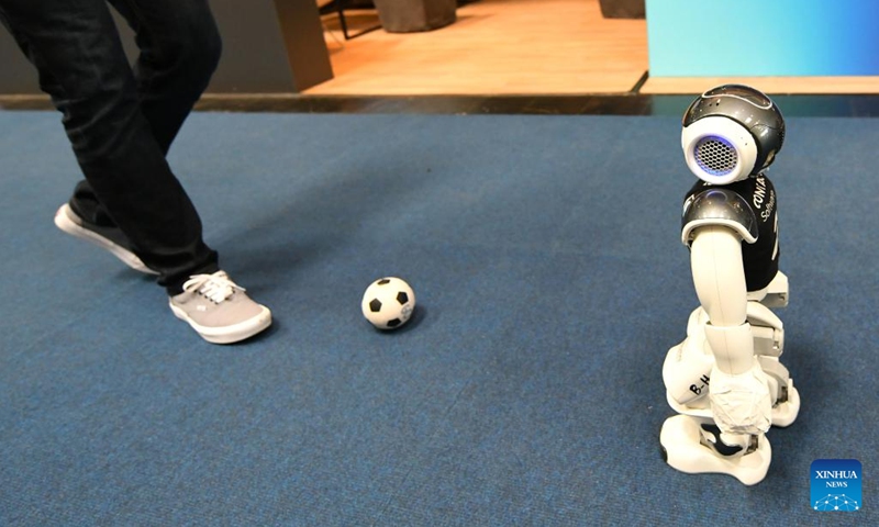 A visitor plays football with an intelligent robot at Hannover Messe 2023 in Hannover, Germany, April 20, 2023. The trade fair, one of the world's largest and lasting from April 17 to April 21, showcases more than 4,000 companies, which present solutions for the production and energy supply of the future.(Photo: Xinhua)