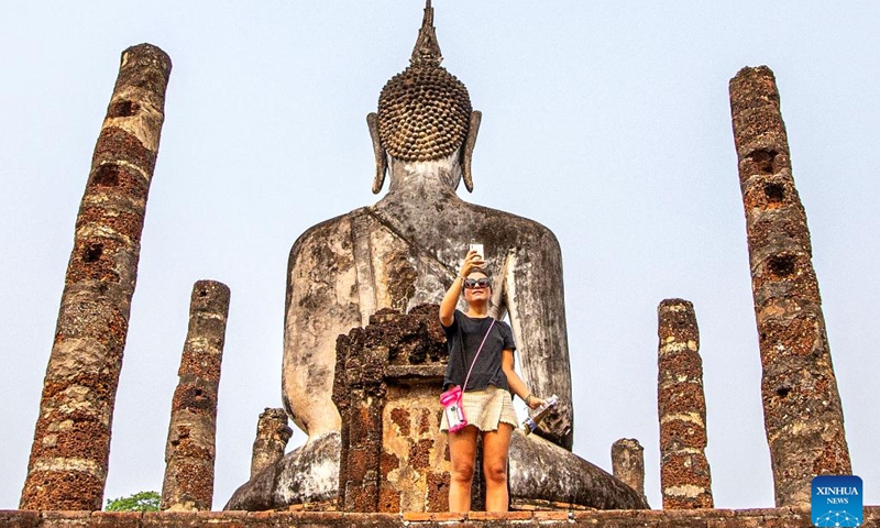 A tourist takes photos at the Historic Town of Sukhothai in Sukhothai, Thailand, April 16, 2023. In 1991, the United Nations Educational, Scientific and Cultural Organization (UNESCO) has inscribed the Historic Town of Sukhothai and Associated Historic Towns on its World Heritage List(Photo: Xinhua)