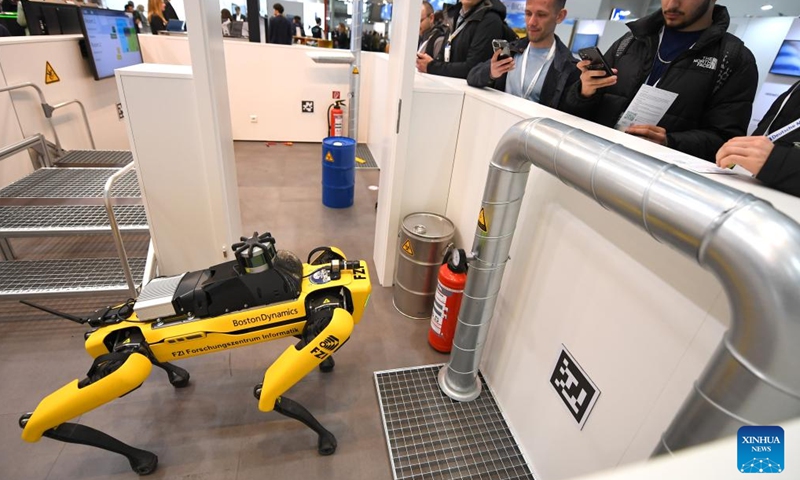 People look at an intelligent inspection robot dog during the Hannover Messe in Hannover, Germany, on April 18, 2023. Germany's leading trade fair for mechanical and electrical engineering kicked off on Monday in Hannover, with the theme of Industrial Transformation - Making the Difference.(Photo: Xinhua)