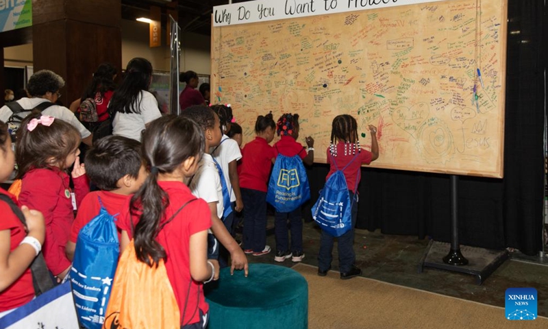 Children write their answers to the question Why Do You Want to Protect the Planet? at the Earthx2023 in Dallas, Texas, the United States, on April 21, 2023. The Earthx2023, an Earth Day event, kicked off here on Friday, highlighting a wide range of environmental and sustainability-related topics.(Photo: Xinhua)