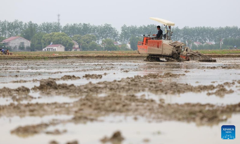 A farmer driving a machine works in a field in Zhongtang Village of Heshan District in Yiyang, central China's Hunan Province, on April 21, 2023. Agricultral machines such as rice transplanter, rotary tiller and drones have helped streamlining the spring ploughing here.(Photo: Xinhua)