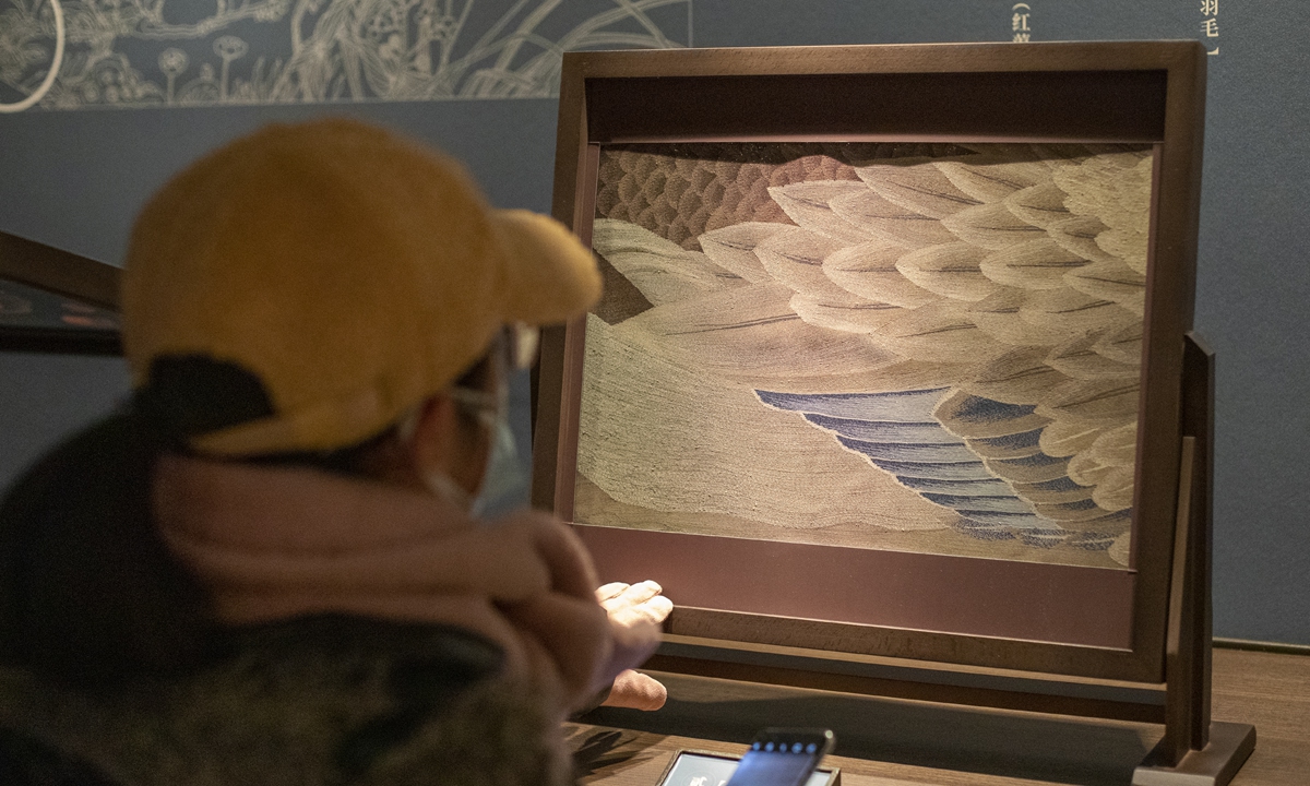 Above: A visitor watches a <em>kesi</em> artwork at an exhibition. Photo: IC