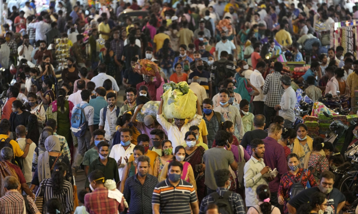 People crowd a market area outside a train station in Mumbai, India, on March 12, 2022. Photo: VCG