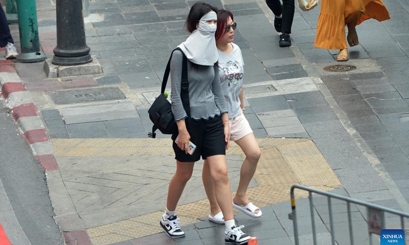 A pedestrian shades herself from the sunshine in Bangkok, Thailand, April 19, 2023. Thailand experienced continuous high temperature recently, with the highest temperature in many provinces exceeding 40 degrees Celsius. The Ministry of Public Health of Thailand reminded the public to reduce outdoor activities. (Photo: Xinhua)