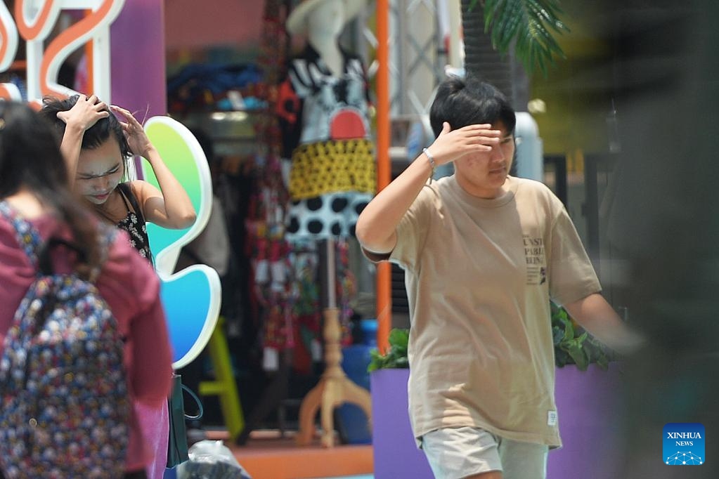 Pedestrians shade themselves from the sunshine in Bangkok, Thailand, April 19, 2023. Thailand experienced continuous high temperature recently, with the highest temperature in many provinces exceeding 40 degrees Celsius. The Ministry of Public Health of Thailand reminded the public to reduce outdoor activities. (Photo: Xinhua)