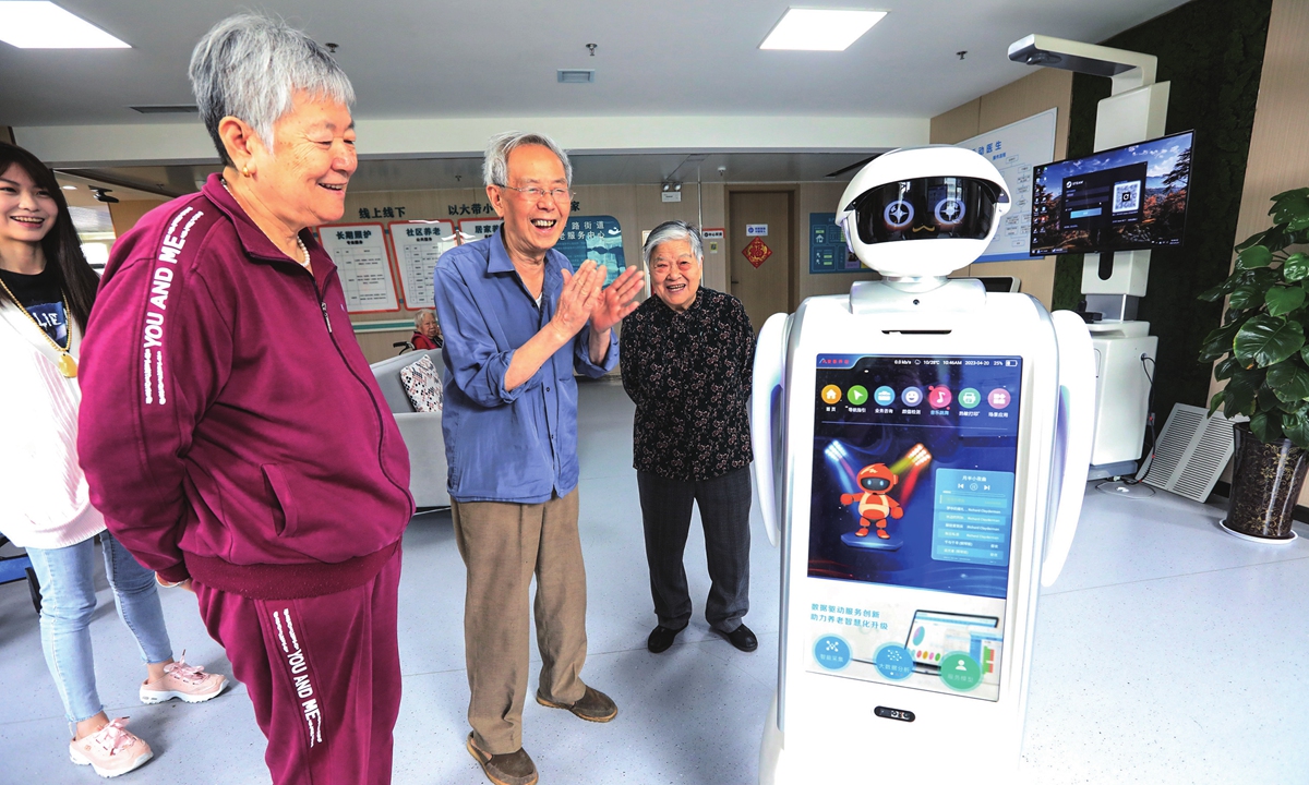 Elderly people interact with a robot at a service center for the elderly in Zhengzhou, Central China's Henan Province on April 20, 2023. With the development of big data, artificial intelligence and other new technologies, more intelligent products provide efficient and convenient services to the elderly, including meals and medical assistance.