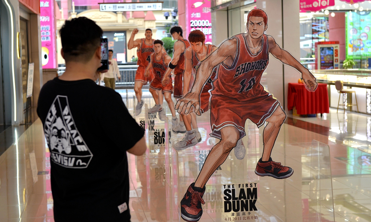 A person takes photos of the figure stands of characters in Japanese animation series Slam Dunk at a shopping mall in Fuzhou, East China's Fujian Province on April 20, 2023. Photo: VCG