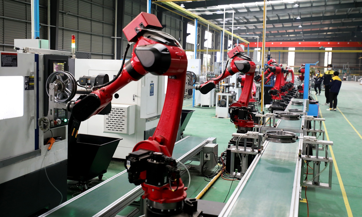 Robotic arms install vehicle and motorcycle wheel parts at an automotive parts assembly factory in a local industrial park in Huaibei city, East China's Anhui Province, on April 22, 2023. China's auto manufacturing and sales are gaining pace this year. 
Photo: VCG