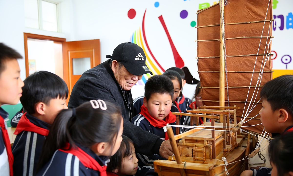 An inheritor of Hongze Lake wooden boat manufacturing techniques introduces a wooden boat to students at a school in Huaian, East China's Jiangsu Province, on April 25, 2023. The techniques to make these boats are the crystallization of the experiences of the people in the area accumulated over thousands of years. Photo: VCG