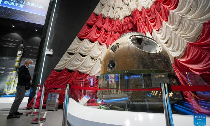A visitor views the main parachute and the return capsule of the Shenzhou-4 spaceship at the China Space Museum in Beijing, capital of China, April 24, 2023. After its renovation, the China Space Museum reopened to the public on the occasion of the Space Day of China on Monday. The museum features exhibition sections covering such themes as carrier rockets, satellites and manned spaceships, exposing visitors to the development of China's aerospace industry.(Photo: Xinhua)