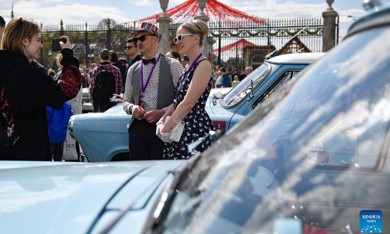 People take pictures during the Stolitsa retro car rally in Moscow, Russia, on April 23, 2023.(Photo: Xinhua)