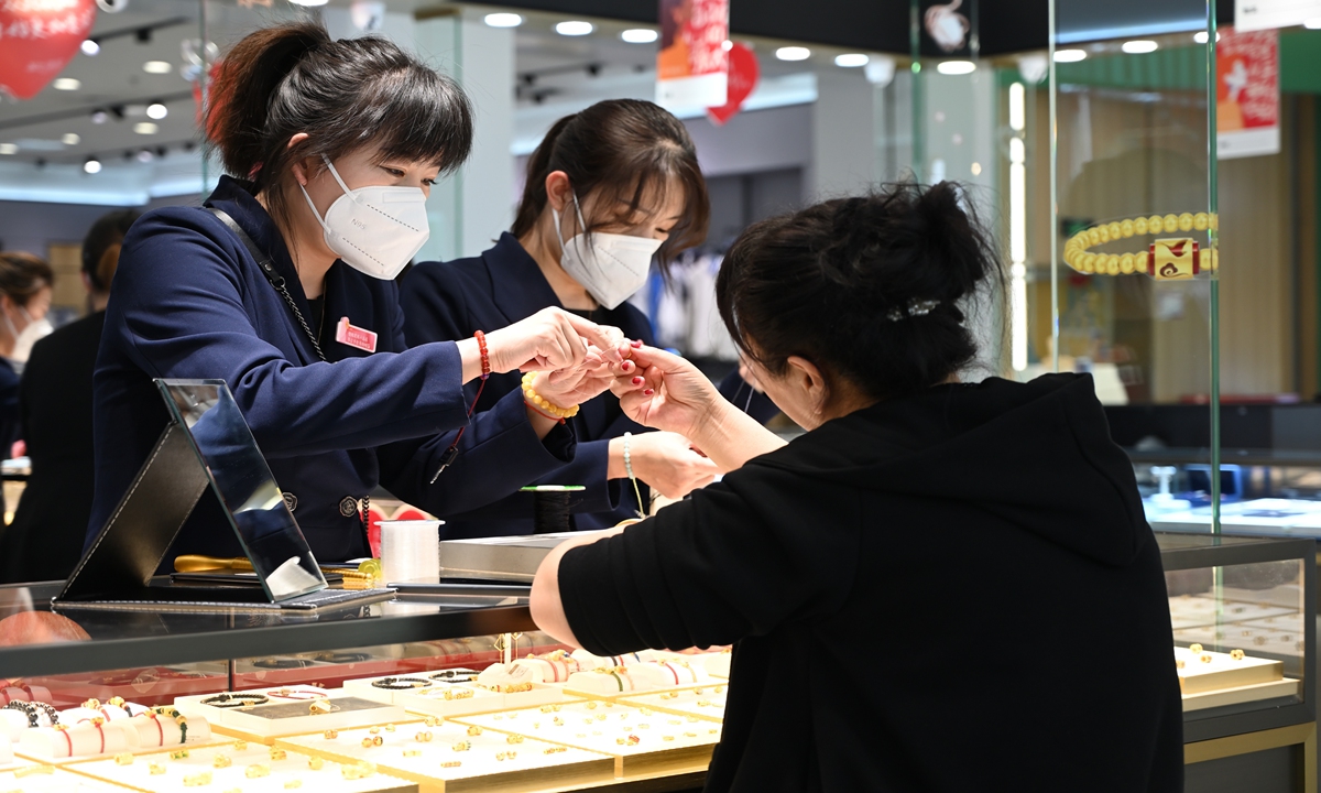 A female consumer shops for gold jewelry in Hohhot,North China's Inner Mongolia Autonomous Region on March 7,2023. Photo: VCG