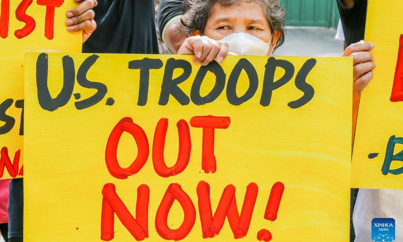 People hold placards during a protest rally against the U.S.-Philippines Balikatan joint military exercises in front of the gate of the Armed Forces of the Philippines (AFP) headquarters in Quezon City, the Philippines, April 11, 2023. More than 17,000 Philippine and U.S. troops on Tuesday kicked off the most extensive joint military activities in decades in the Philippines amid criticisms that it escalates tension in the region rather than peace and stability.(Photo: Xinhua)