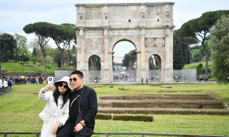 Chinese tourists take selfies near the Arch of Constantine in Rome, Italy, on May 1, 2023. (Xinhua/Jin Mamengni)
