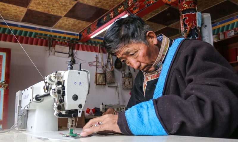 Sonam Qoipei makes a horse bag in Nang County of Nyingchi, southwest China's Tibet Autonomous Region, April 19, 2023.