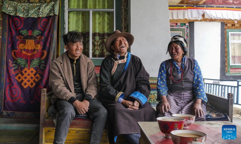 Sonam Qoipei (C) chats with his family members in Nang County of Nyingchi, southwest China's Tibet Autonomous Region, April 19, 2023.