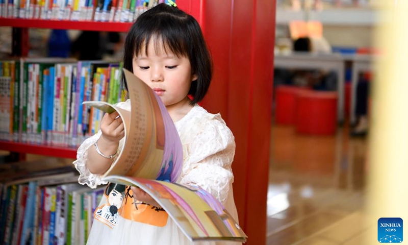 A child reads a book at a library during the May Day holiday in Pingdingshan City, central China's Henan Province, May 1, 2023. (Xinhua/Hao Yuan)