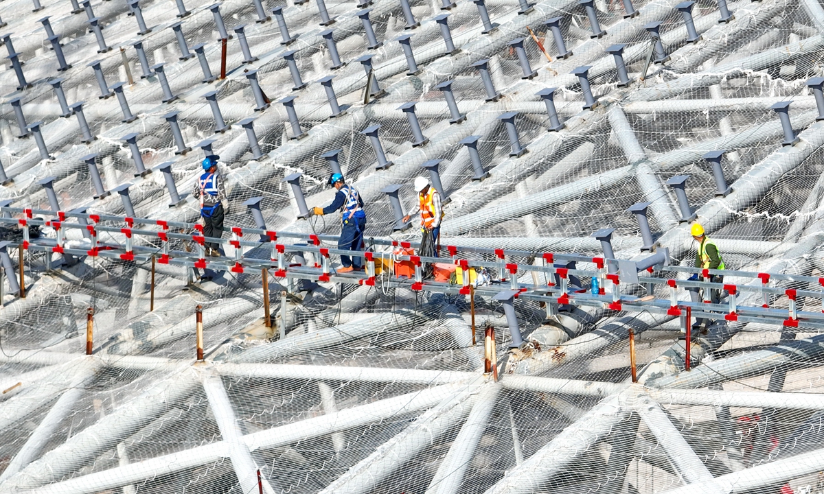 Workers install steel structures on top of a stadium in Ganzhou, East China's Jiangxi Province on May 3, 2023. In 2021, value added output by China's sports-related facilities reached 23.6 billion yuan ($3.41 billion), according to the National Bureau of Statistics. 