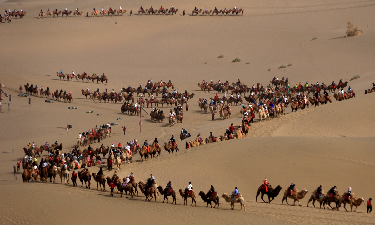 Tourists riding camels crowd at the Crescent Moon Spring and Mingsha Mountain scenic in Dunhuang, Jiuquan of Northwest China's Gansu Province on May 1, 2023.
