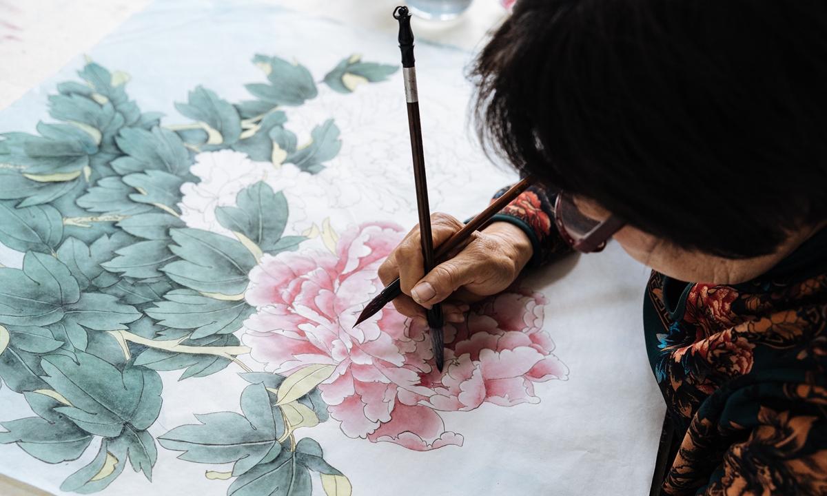 An artist works on a peony painting at the Juye Painting and Calligraphy Institute on April 30, 2023. Photo: Li Hao/Global Times